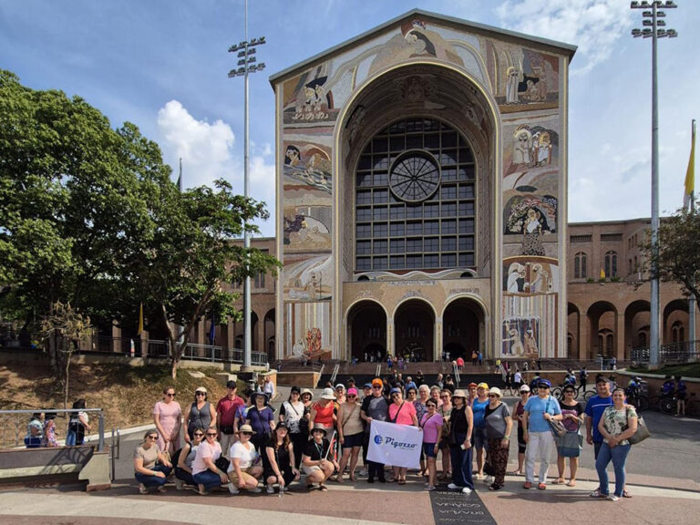 grupo de turista com bandeira do pigozzo em frente a uma igreja